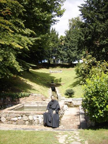 P. Jos Ignacio Busta seduto alla fontana nel parco Rus Cassiciacum