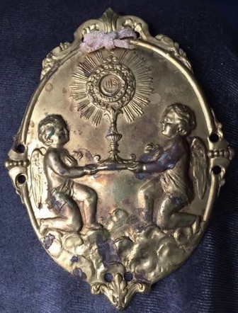 La medaglia con l'allegoria eucaristica appuntata sulla mozzetta rossa
