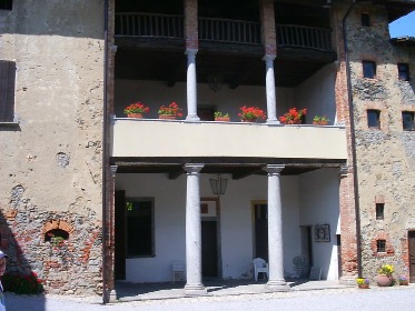 Il triplo loggiato della parte vecchia dell'edificio con un doppio colonnato e la loeugia in legno